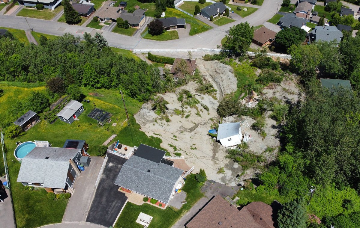 A building lies at the bottom of a landslide which destroyed a house and forced 77 residences to be evacuated, Monday, June 20, 2022  in Saguenay, Que. 