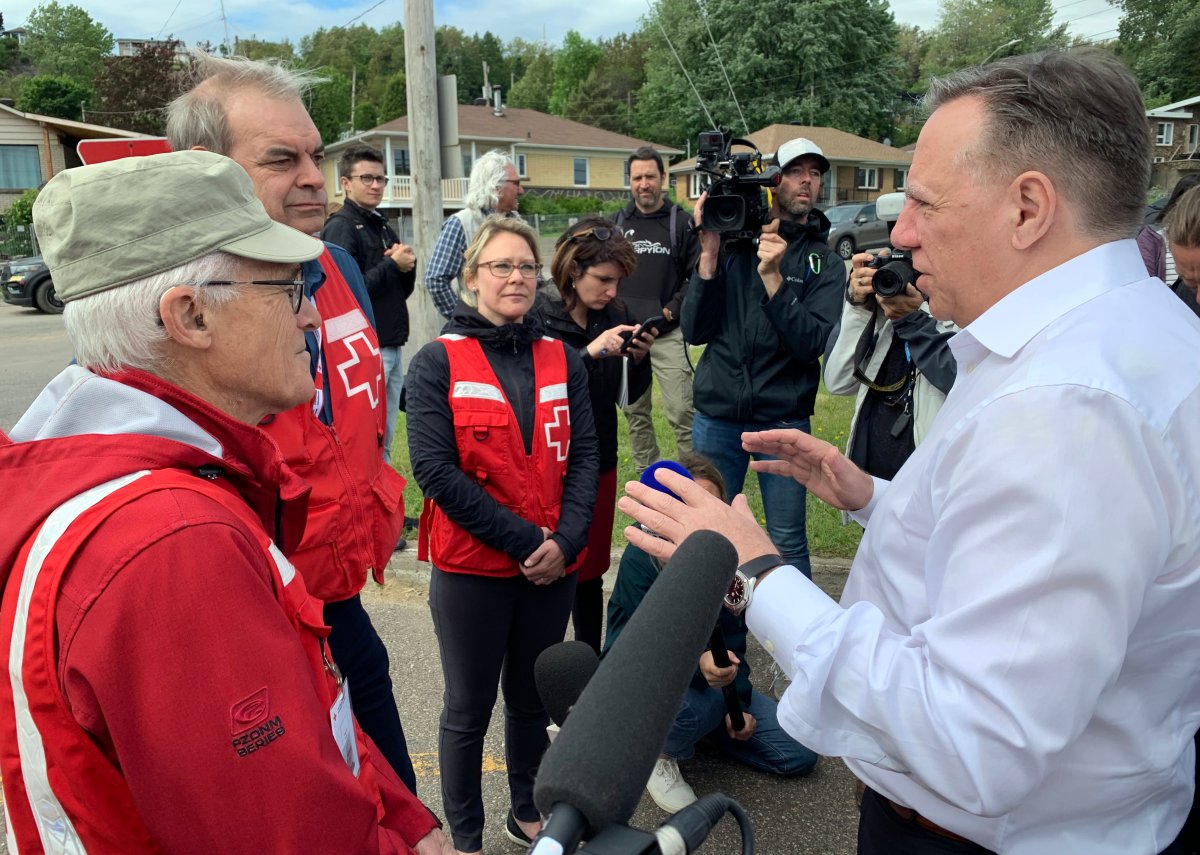 Quebec Prime Minister François Legault speaks with volunteers in La Baie, Saguenay, Que., where close to 200 people have been evacuated from their homes due to the threat of landslides, Wednesday, June 22, 2022.