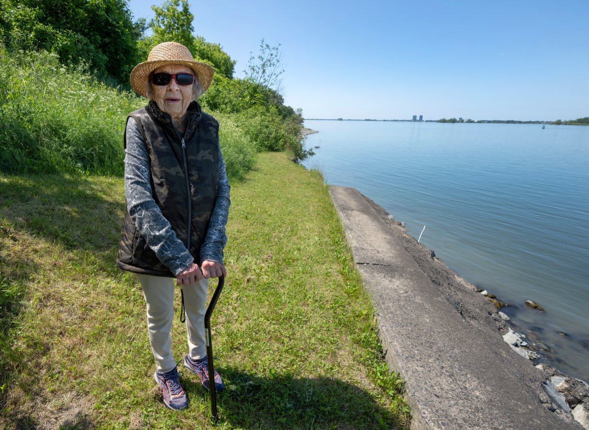 Angelique Beauchemin looks at the erosion on her property on the shore of the St. Lawrence River, in Vercheres, Que., Monday, June 20, 2022. 
