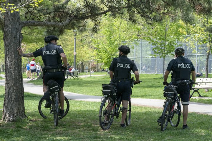 Bicycle police officers keep an eye on Trinity Bellwoods Park in Toronto on Sunday, May 24, 2020.  