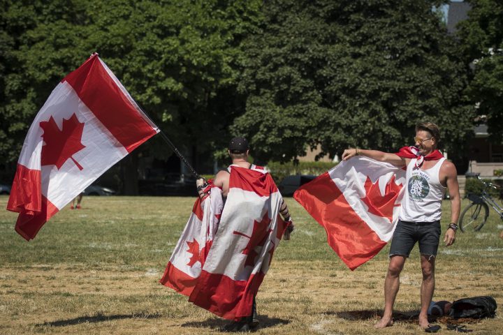 Fred Yurichuk (right) holds out his Canadian Flag after being approached by another patriotic Canadian at Trinity Bellwoods Park in Toronto on Canada Day, Wednesday, July 1, 2020. 