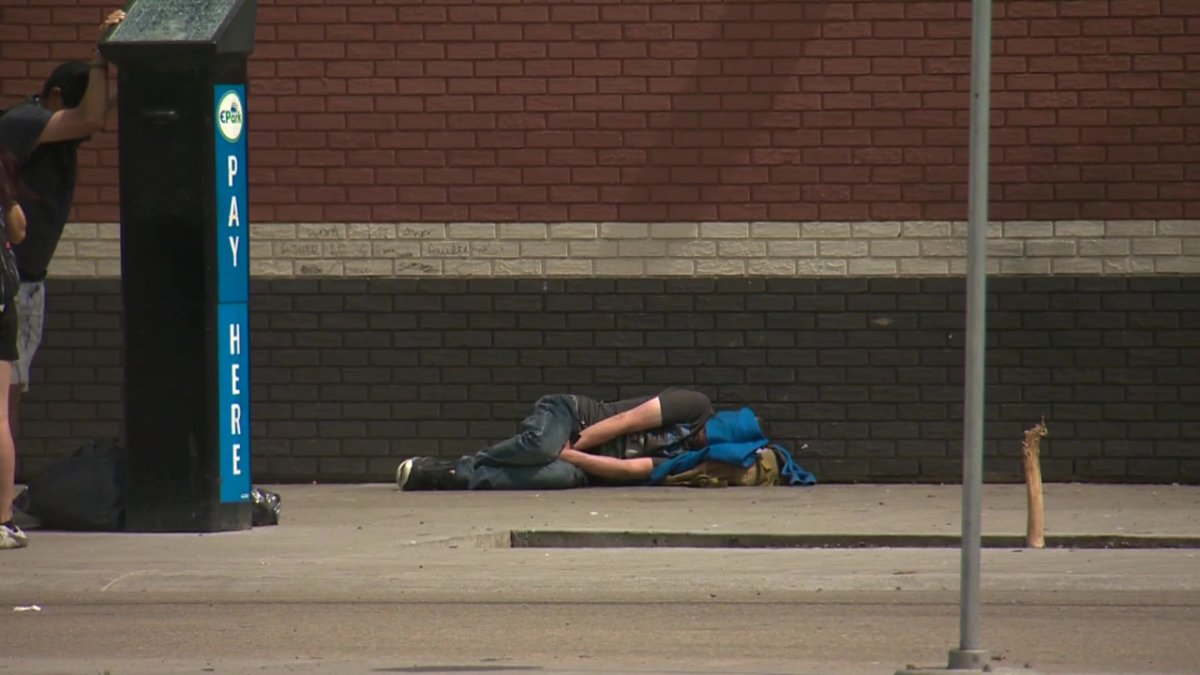 A person sleeping outside the Hope Mission homeless shelter in central Edmonton on June 13, 2022.