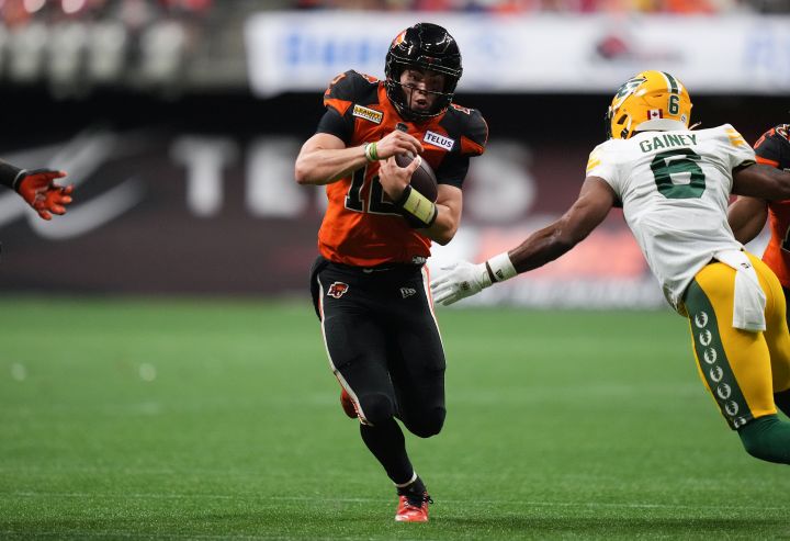 B.C. Lions quarterback Nathan Rourke, centre, runs past Edmonton Elks' Ed Gainey (6) on his way to scoring a touchdown during the second half of CFL football game in Vancouver, on Saturday, June 11, 2022. 