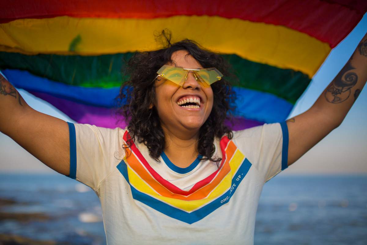 A woman holding a Pride flag.