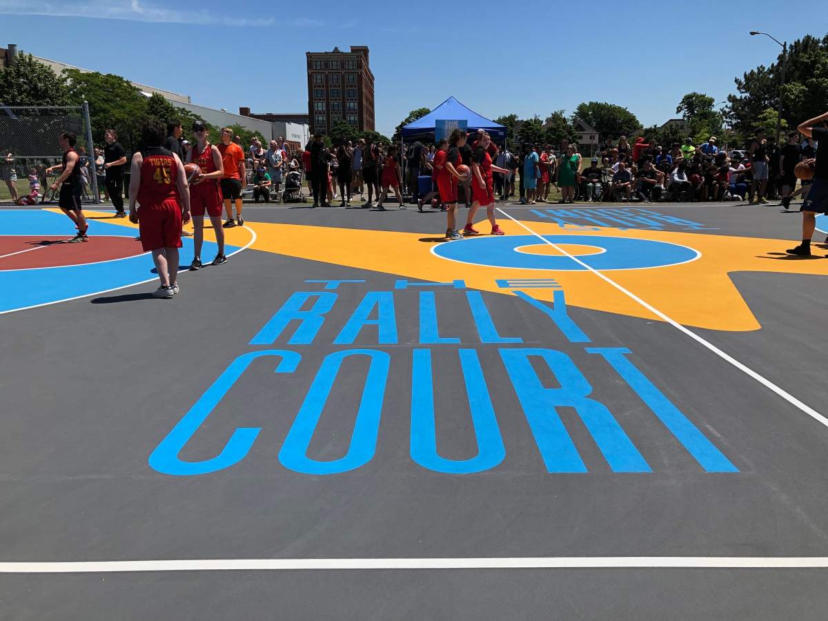 A basketball court that has the words "THE RALLY COURT" in large block blue letters.