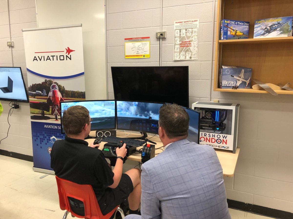 TVDSB Director of Education Mark Fisher (right) is shown the ropes by a student in Aviation School during a demonstration of a new flight simulator on Thursday.