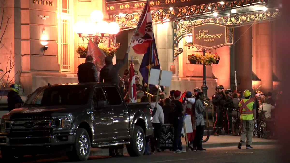 Protesters gather outside the Fairmont Palliser hotel in Calgary Wednesday, June 1, 2022.