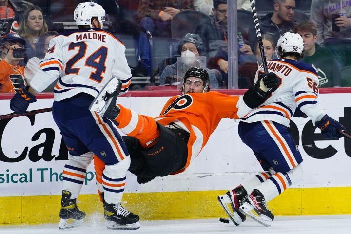 Philadelphia Flyers’ Zack MacEwen, center, collides with Edmonton Oilers’ Brad Malone, left, and Kailer Yamamoto during the second period of an NHL hockey game, Tuesday, March 1, 2022, in Philadelphia.