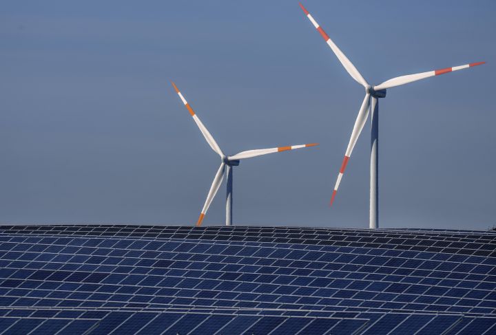 FILE -- Wind turbines turn behind a solar farm in Rapshagen, Germany, Thursday, Oct. 28, 2021. 