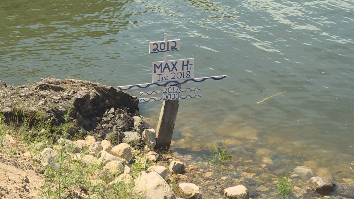 A sign on the edge of Shuswap Lake measures how the current lake level compares to previous years’ high water levels.