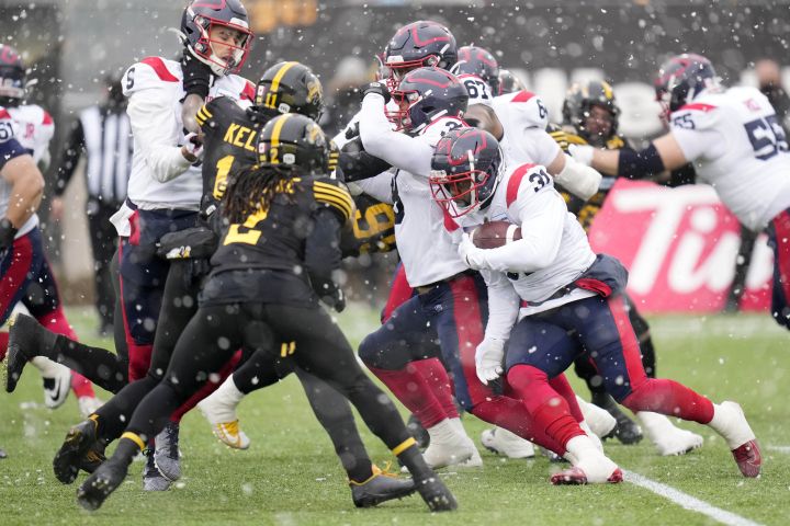Montreal Alouettes running back William Stanback (31) runs the ball as Hamilton Tiger-Cats defensive back Tunde Adeleke (2) goes for the tackle during first half CFL division semi-final football action in Hamilton, Ont., on Sunday, November 28, 2021.