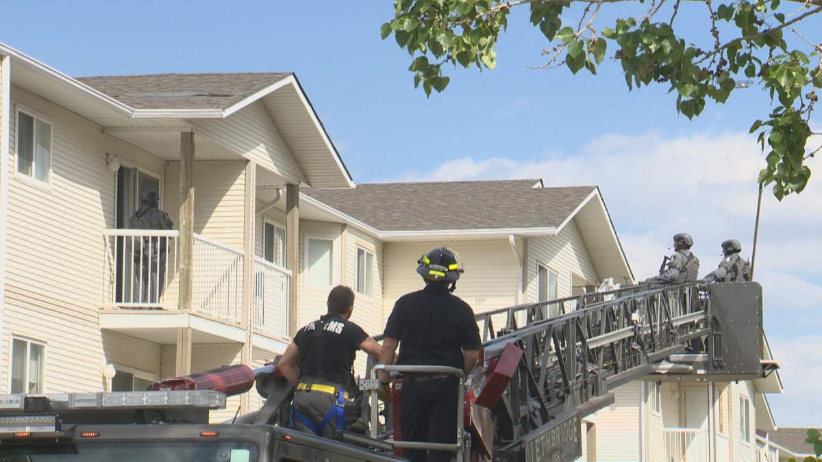 Firefighters raise a pair of LPS tactical officers up to a third floor apartment, while another officer stands on an adjacent balcony. June 2, 2022.