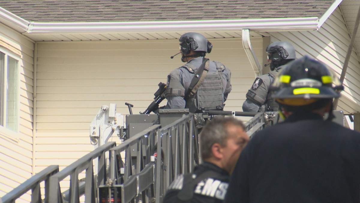 Firefighters raise two LPS officers in the bucket of a fire truck on June 2, 2022.