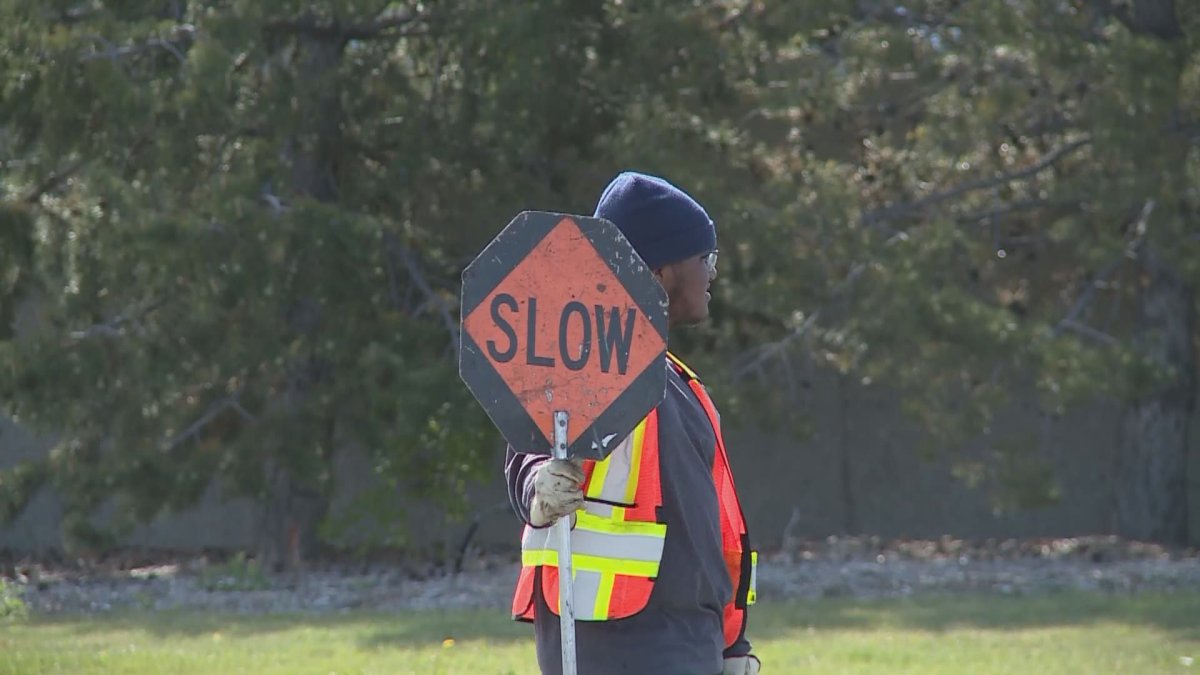 A construction working holds a "slow" sign.