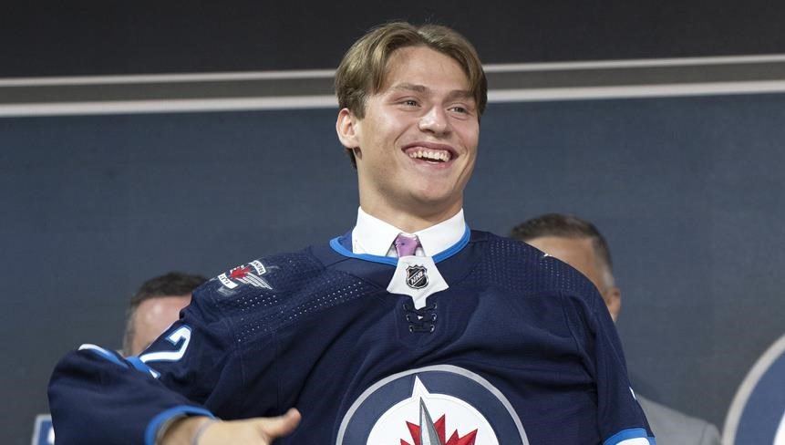 Winnipeg Jets’ Rutger McGroarty puts on his jersey during the first round of the 2022 NHL Draft Thursday, July 7, 2022 in Montreal.
