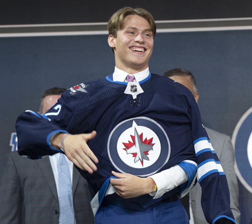 Winnipeg Jets Rutger McGroarty puts on his jersey during the first round of the 2022 NHL draft on Thursday, July 7, 2022 in Montreal.