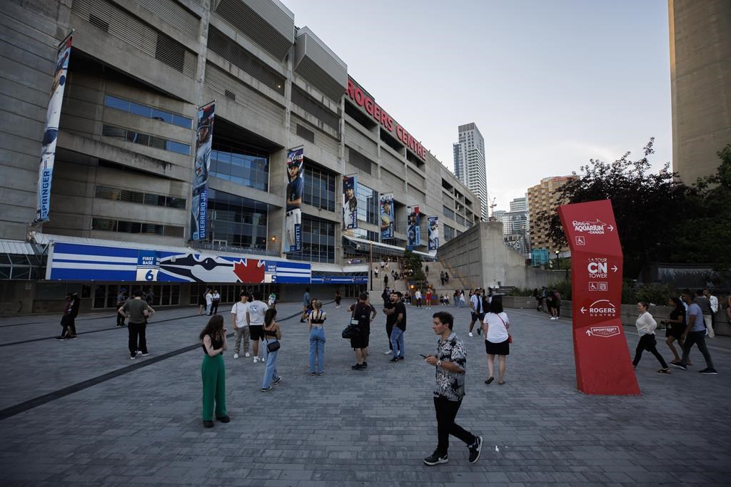 Fans outside the Rogers Centre after The Weeknd's Toronto show is postponed, amid telecommunication company Rogers' service trouble, Friday, July 8, 2022. THE CANADIAN PRESS/Cole Burston.