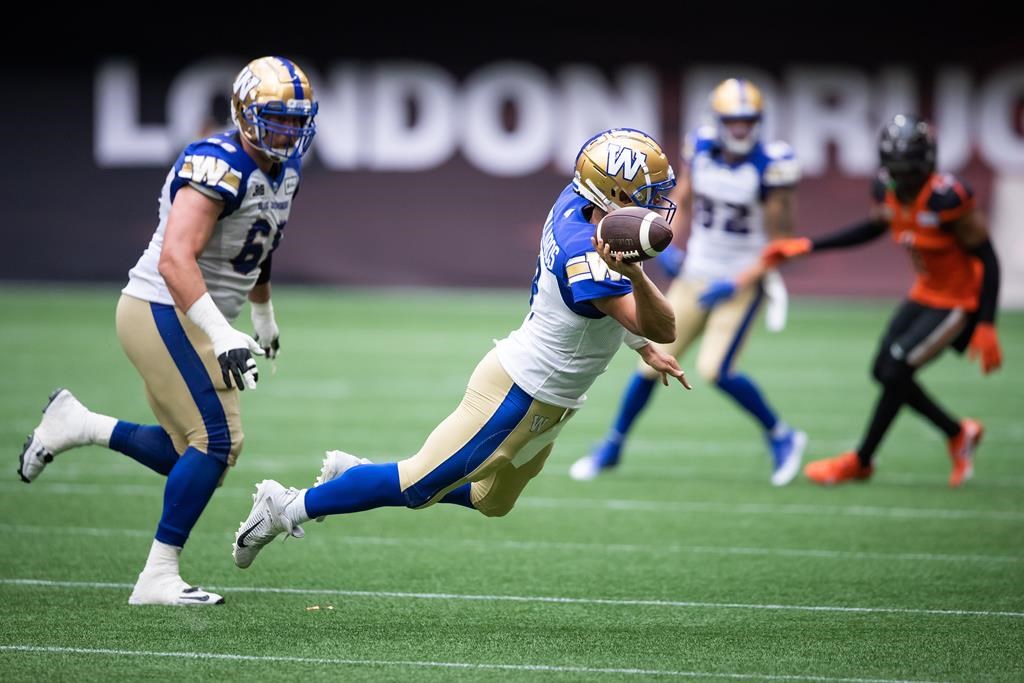 Winnipeg Blue Bombers quarterback Zach Collaros completes a pass to Dalton Schoen, not seen, while falling during the second half of CFL football game against the B.C. Lions in Vancouver, on Saturday, July 9, 2022.