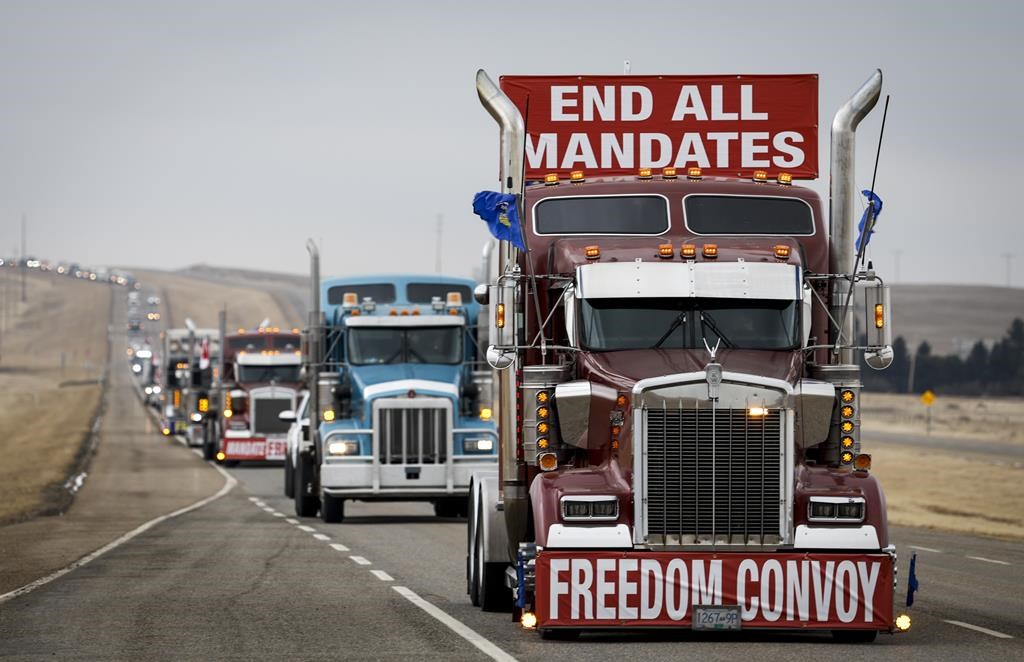Anti-COVID-19 vaccine mandate demonstrators leave in a truck convoy after blocking the highway at the busy U.S. border crossing in Coutts, Alta., Tuesday, Feb. 15, 2022.
