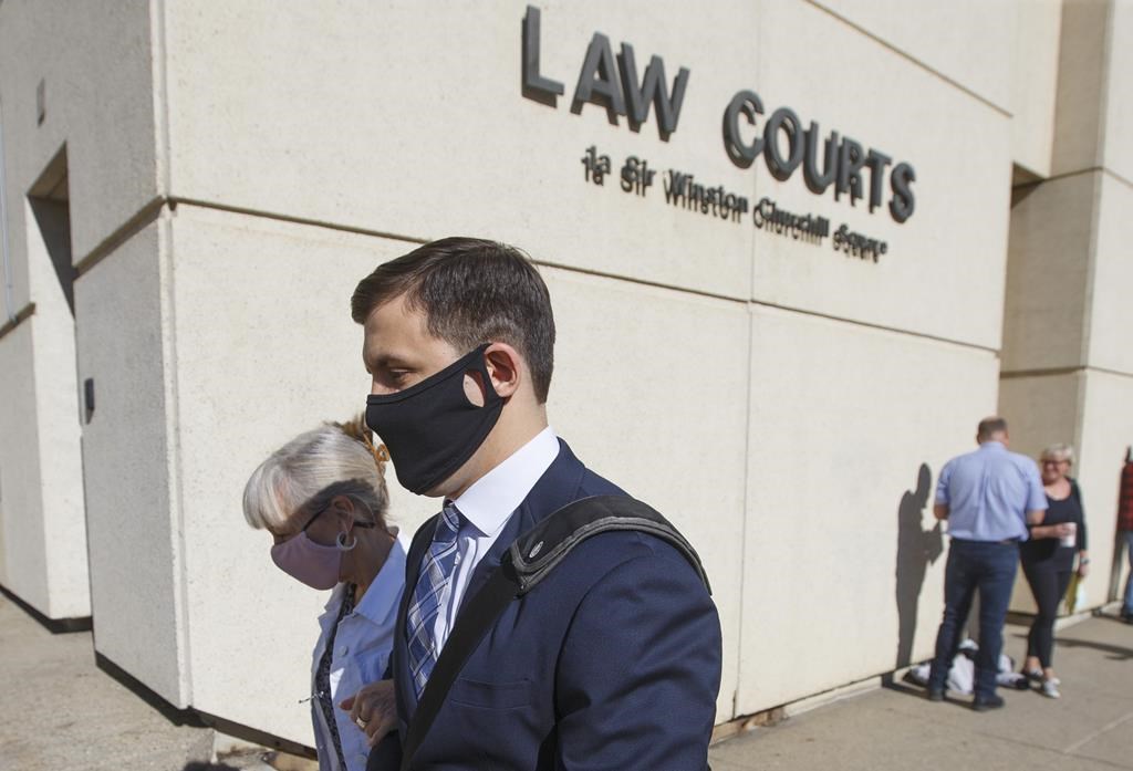 Matthew McKnight and his mother walk into court, in Edmonton on Friday, July 10, 2020.