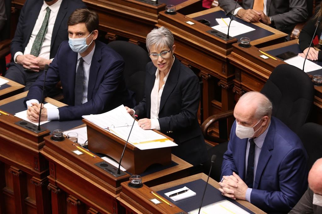 British Columbia's attorney general David Eby, left, and Premier John Horgan, look on as Finance Minister Selina Robinson delivers the budget speech in the legislative assembly in Victoria, on February 22, 2022. Robinson says she has decided not to run to replace John Horgan as premier. 