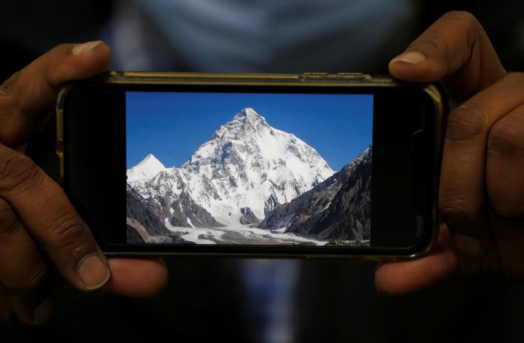 A photo of K2, the world's second-highest mountain, is displayed on a cellphone in Islamabad, Pakistan, Tuesday, Feb. 9, 2021. A Quebec mountaineer has died while climbing the world's second highest peak in Pakistan.THE CANADIAN PRESS/AP/Anjum Naveed.