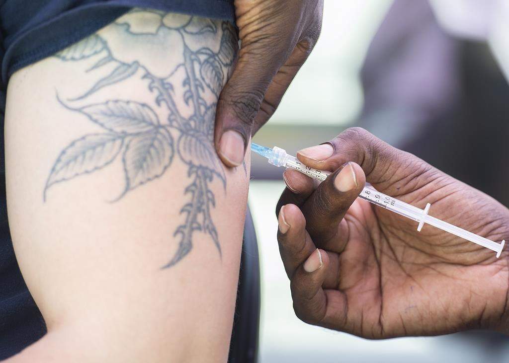 A man receives a monkeypox vaccine at an outdoor walk-in clinic in Montreal, Saturday, July 23, 2022. THE CANADIAN PRESS/Graham Hughes.