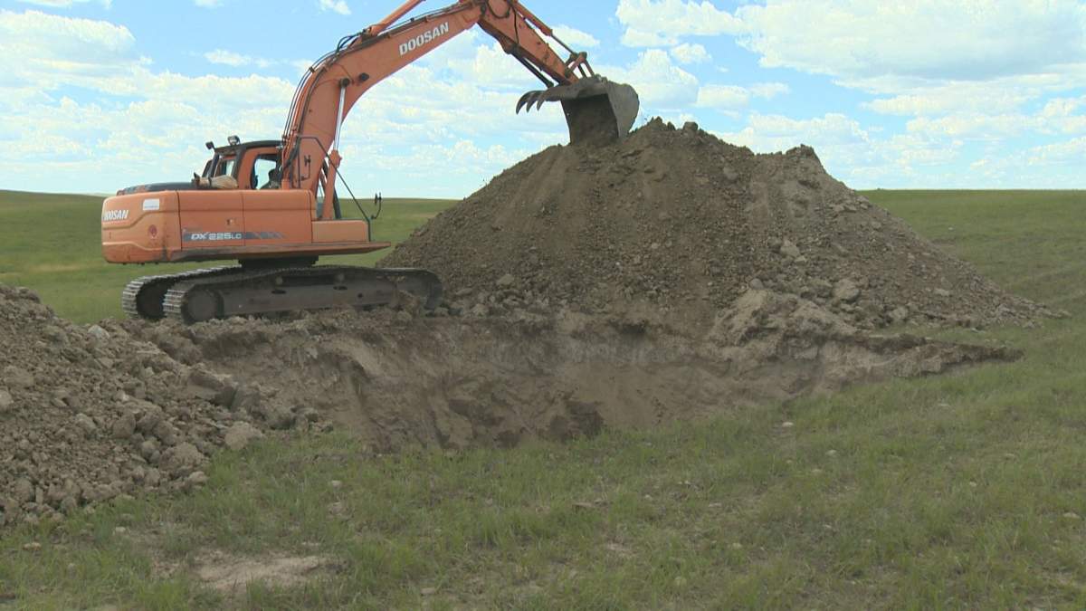 Shay Briere digs a hole to bury the dead cattle.