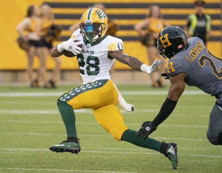 Edmonton Elks running back Sherman Badie (28) fends off Hamilton Tiger Cats linebacker Simoni Lawrence (21) during first half CFL football game action in Hamilton, Ont. on July 1, 2022.