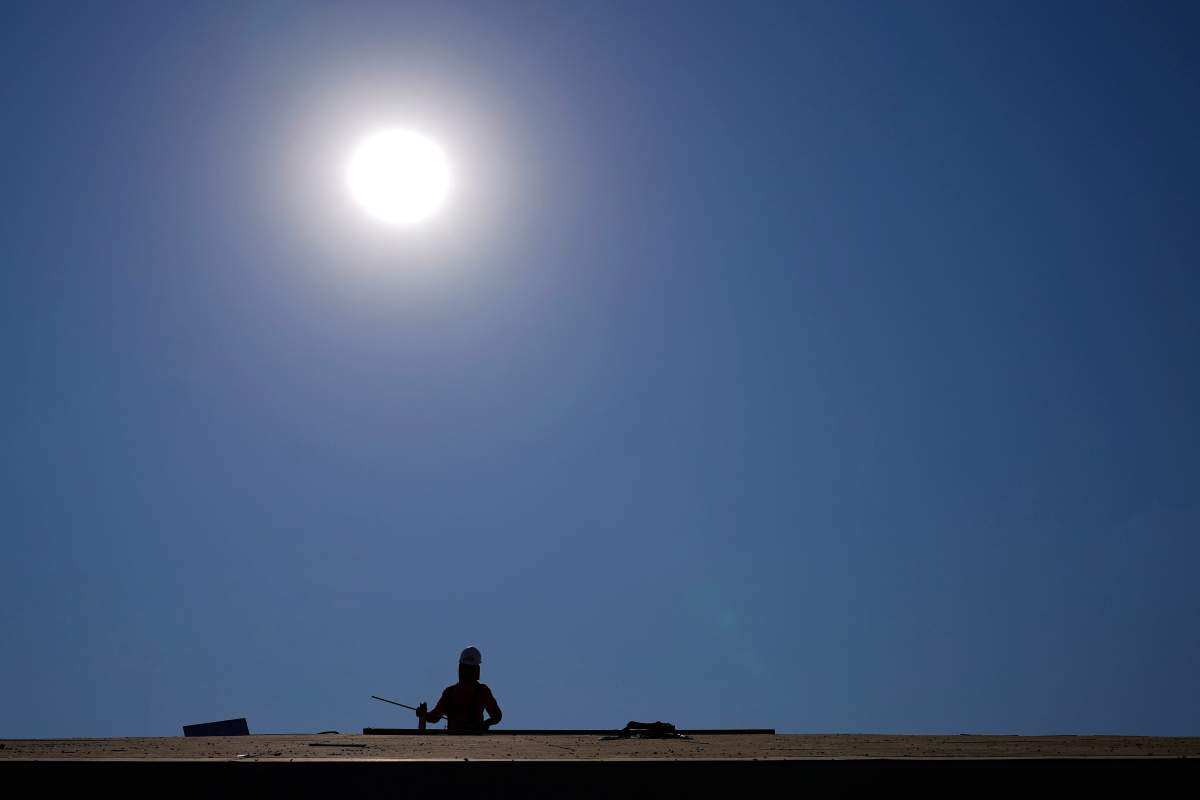 A roofer works on a new roof in a housing development while the sun beats down on him as the heat wave continues Thursday, June 17, 2021, in Phoenix.