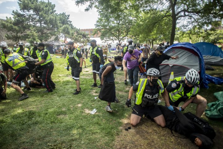 Police and city workers detain encampment supporters as they clear Lamport Stadium encampment for the homeless in Toronto on Wednesday, July 21 , 2021. THE CANADIAN PRESS IMAGES/Chris Young.