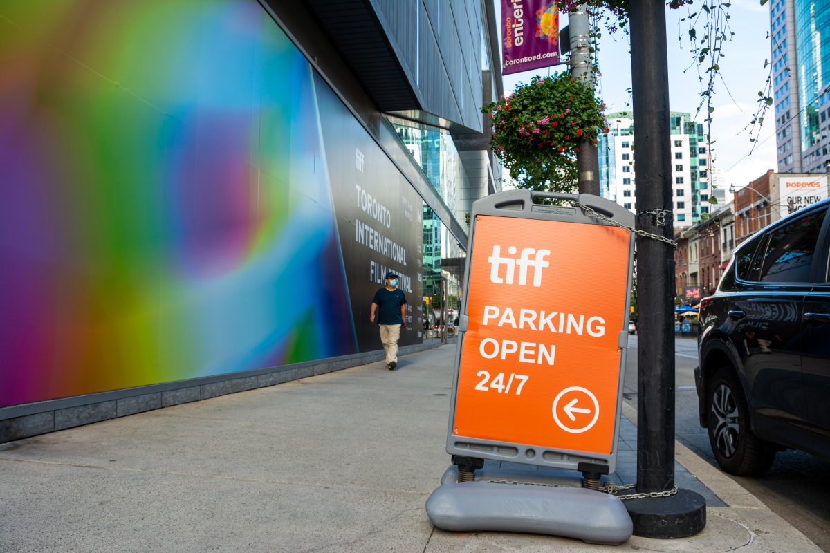 A person wearing a mask is seen walking in front of the TIFF Bell Lightbox and the TIFF parking garage sign on the first day of the 2021 Toronto International Film Festival (TIFF) where in the past a large line up will fill the space with movie goers waiting for the movie screening in Toronto on September 9, 2021.
THE CANADIAN PRESS IMAGES/Dominic Chan.
