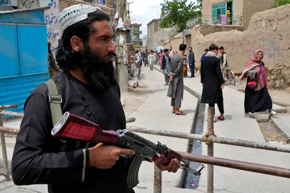 A Taliban fighter stands guard at the site of an explosion in front of a school, in Kabul, Afghanistan, Tuesday, April 19, 2022. An Afghan police spokesman says explosions targeting educational institutions in Kabul have killed at least six civilians and injured over 10 others. Khalid Zadran said Tuesday the blasts occurred in the mostly-Shiite Muslim area in the west of Afghanistan's capital. (AP Photo/Ebrahim Noroozi).