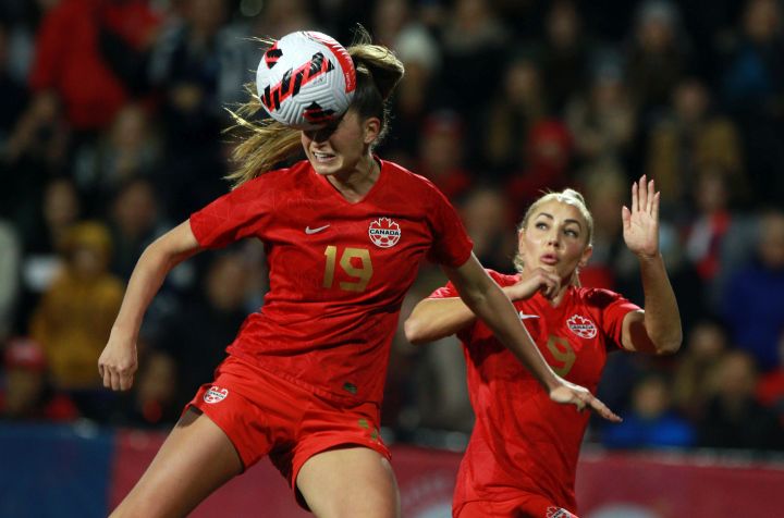 Canada's Jordyn Huitema heads the ball away as Adriana Leon backs her up during first half soccer action against Nigeria during the national team celebration tour at Starlight Stadium in Langford, B.C., Monday, April 11, 2022. 
