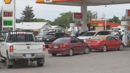Vehicles line up at a gas station in Claresholm, Alta.