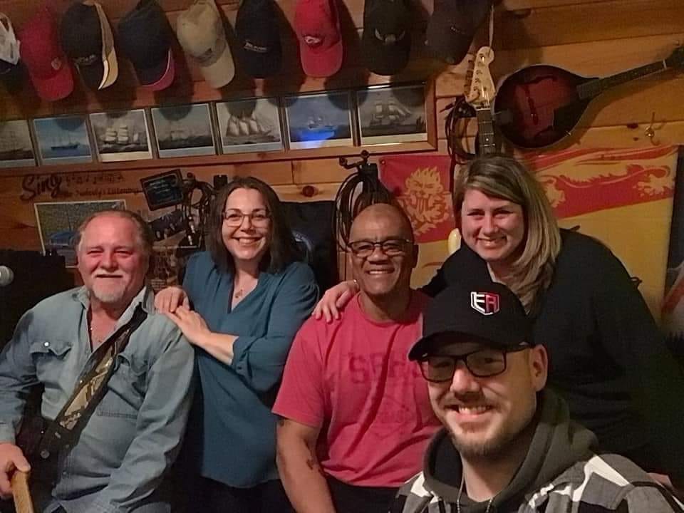 Darrell Richards, middle, sits with members of the band Ryan Drive