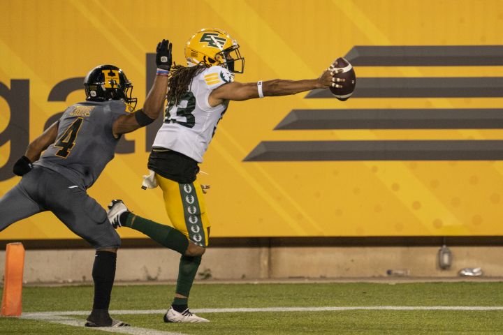 Hamilton Tiger Cats wide receiver Papi White (4) cannot catch Edmonton Elks defensive back Jalen Collins (33) who runs the ball into the end zone after recovering a fumble by Hamilton Tiger Cats quarterback Dane Evans (9) late in the fourth quarter of CFL football game action in Hamilton, Ont., Friday, July 1, 2022.
