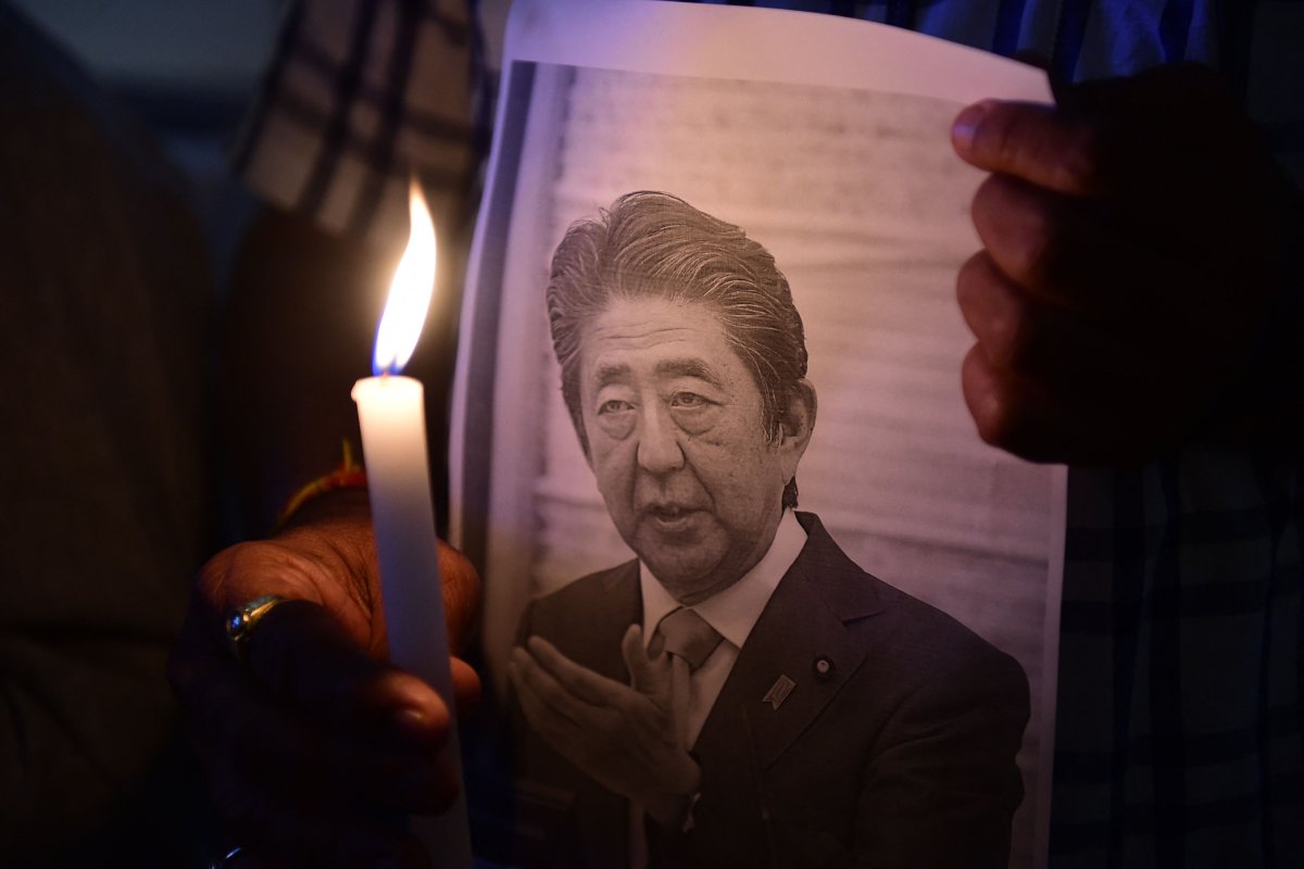 Photo of a person holding a photo of Shinzo Abe