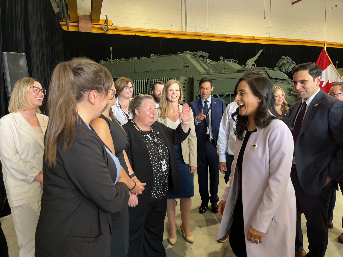 Canadian Defence Minister Anita Anand (second from right) shares a laugh with employees during a visit to General Dynamics Land Systems in London, Ont.