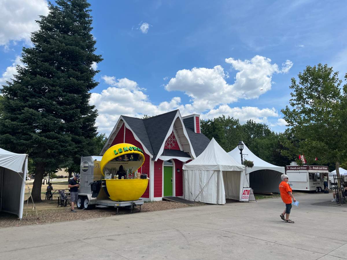 Santa’s House sits nestled behind a vendor and an ATM machine tent during the 47th annual Home County Music and Art Festival in Victoria Park.