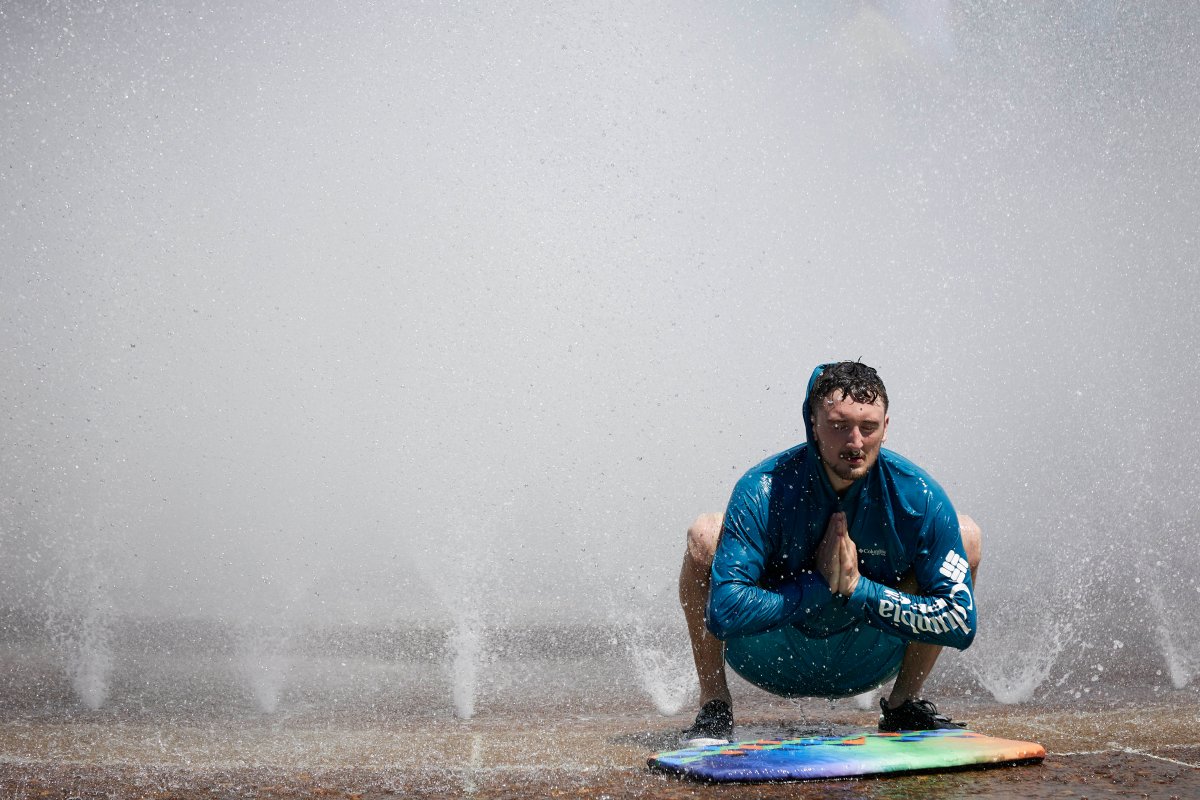 Jesse Moore cools off in the Salmon Street Springs fountain in Portland, Ore., Tuesday, July 26, 2022. Temperatures are expected to top 100 degrees F (37.8 C) on Tuesday and wide swaths of western Oregon and Washington are predicted to be well above historic averages throughout the week. 