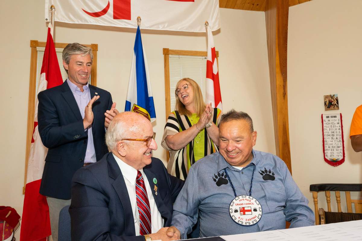 Lt.-Gov. Arthur J. LeBlanc and Grand Chief Norman Sylliboy shake hands during the proclamation ceremony for the Mi’kmaw Language Act. Premier Tim Houston and L’nu Affairs Minister Karla MacFarlane are seen in the back applauding.