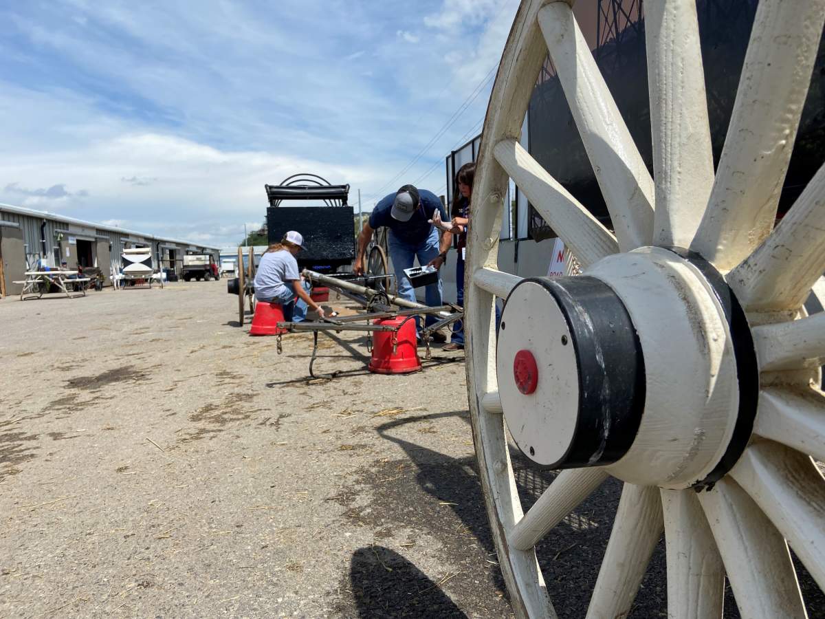 Vern Nolin and his daughters give his wagon a fresh coat of paint before Friday’s first race.