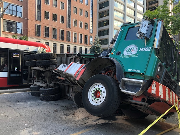 Garbage truck flips on its side colliding with streetcar on July 26, 2022.