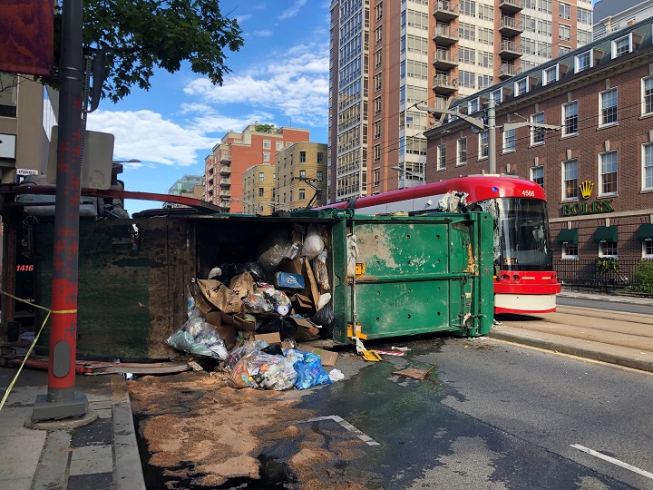 Garbage truck flips on its side colliding with streetcar on July 26, 2022.