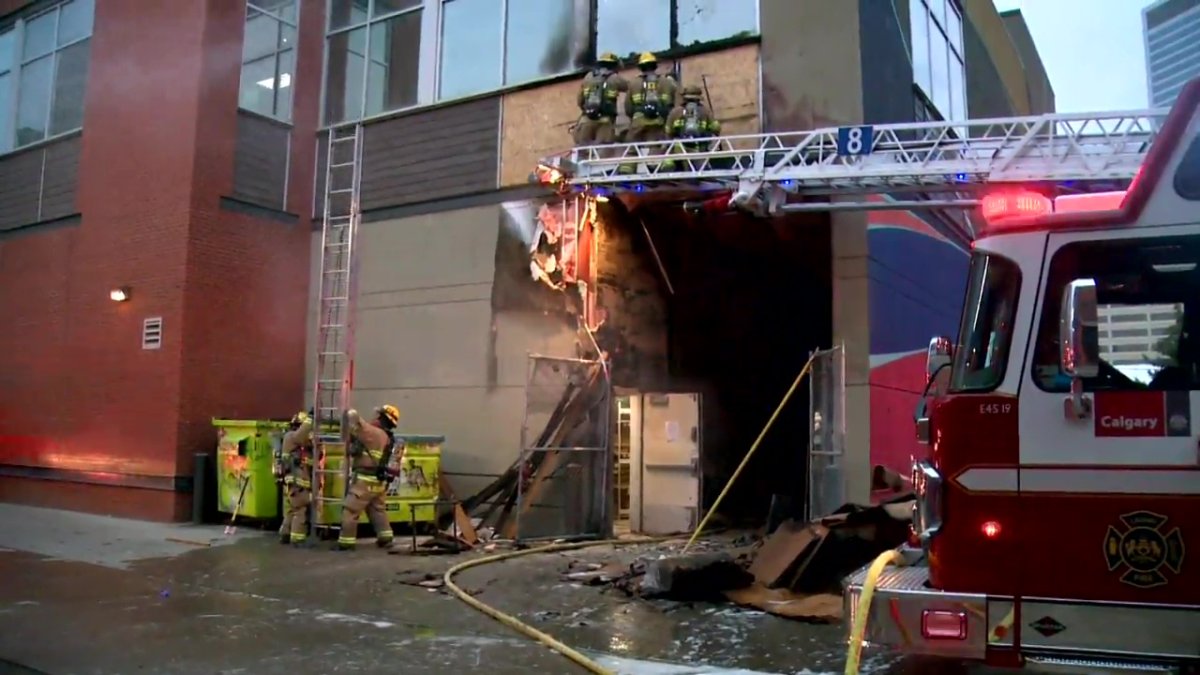 Calgary firefighter's work to tackle a blaze in the alleyway of the 800 block of 10th Avenue SW on July 3, 2022.