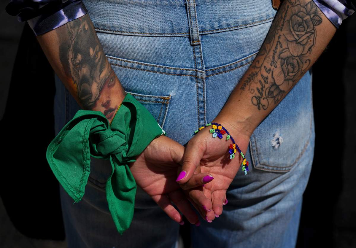 A woman wears a green bandana on her wrist while protesting outside the U.S. embassy.