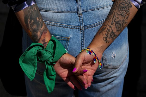 A woman wears a green bandana on her wrist while protesting outside the U.S. embassy.
