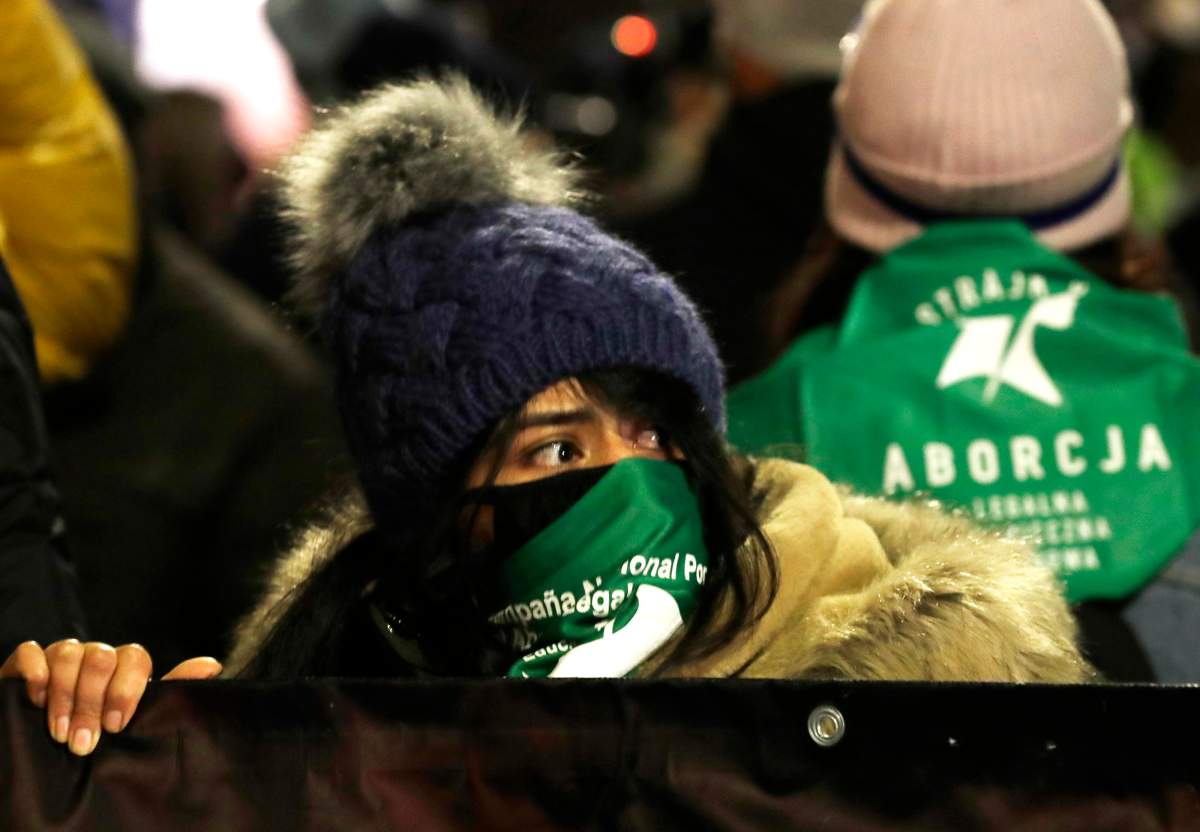 An abortion rights protester in Poland wears a green bandana.