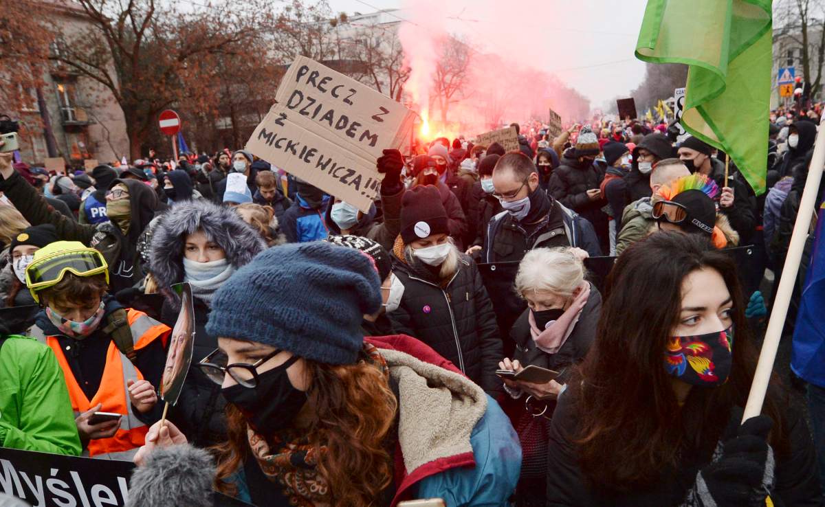 Abortion rights protesters in Poland wave green flags during a march.